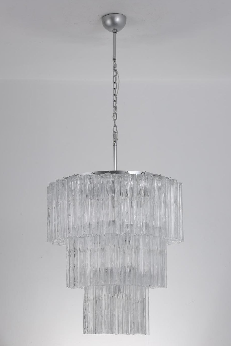De gemaakte hanglamp met drie lagen glazen staven