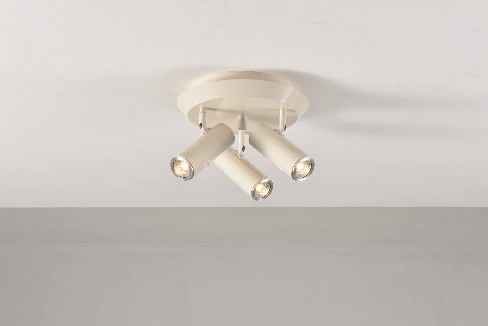 Plafondlamp Flush in beige met de drie spots aan en naar voren gericht