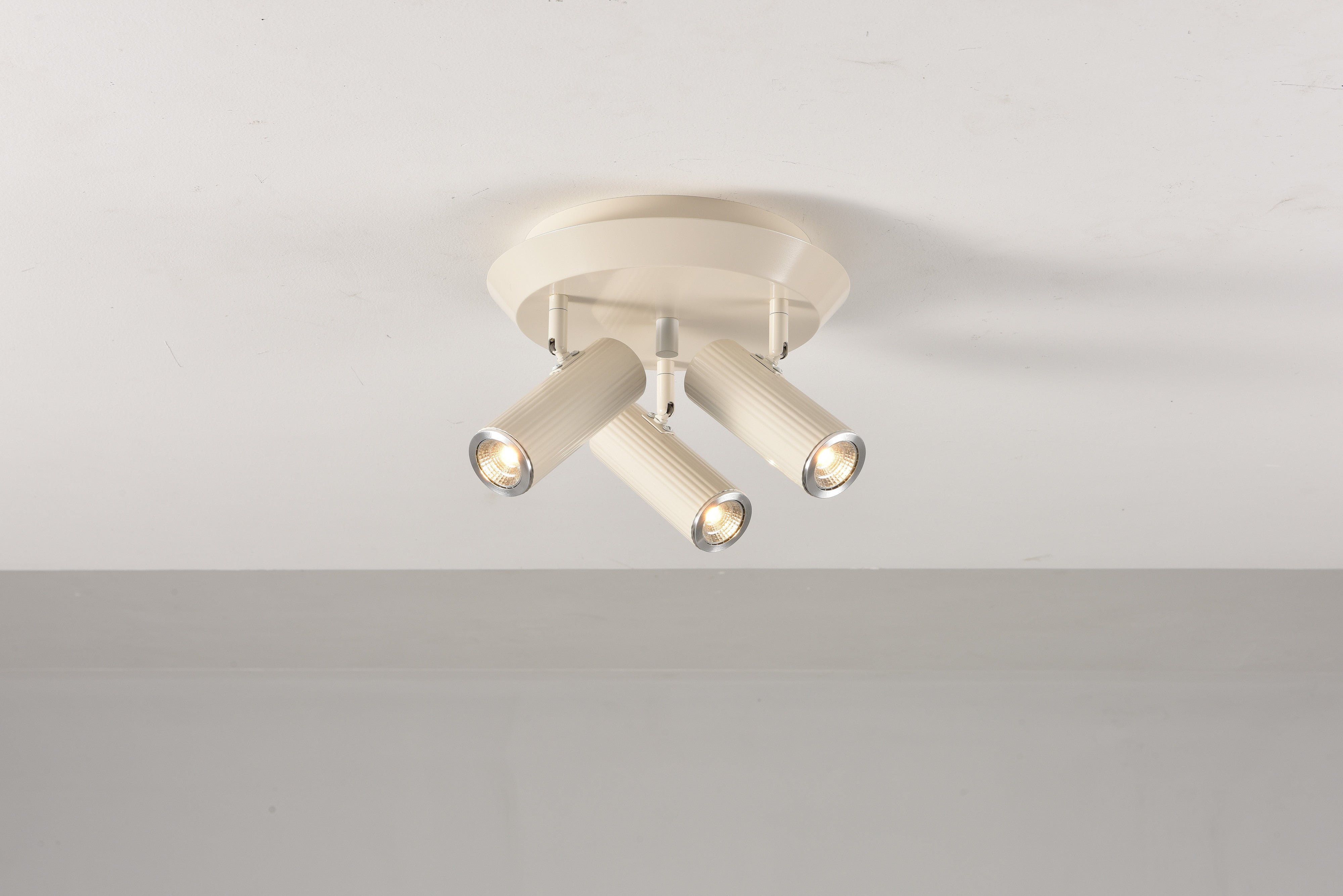 Plafondlamp Flush in beige met de drie spots aan en naar voren gericht