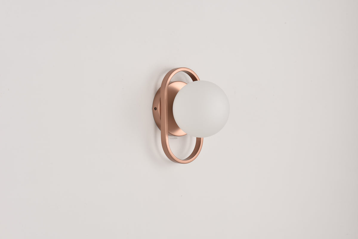 Wandlamp Jessica in brons met opaalwitte bol in een bronzen ring op een witte wand