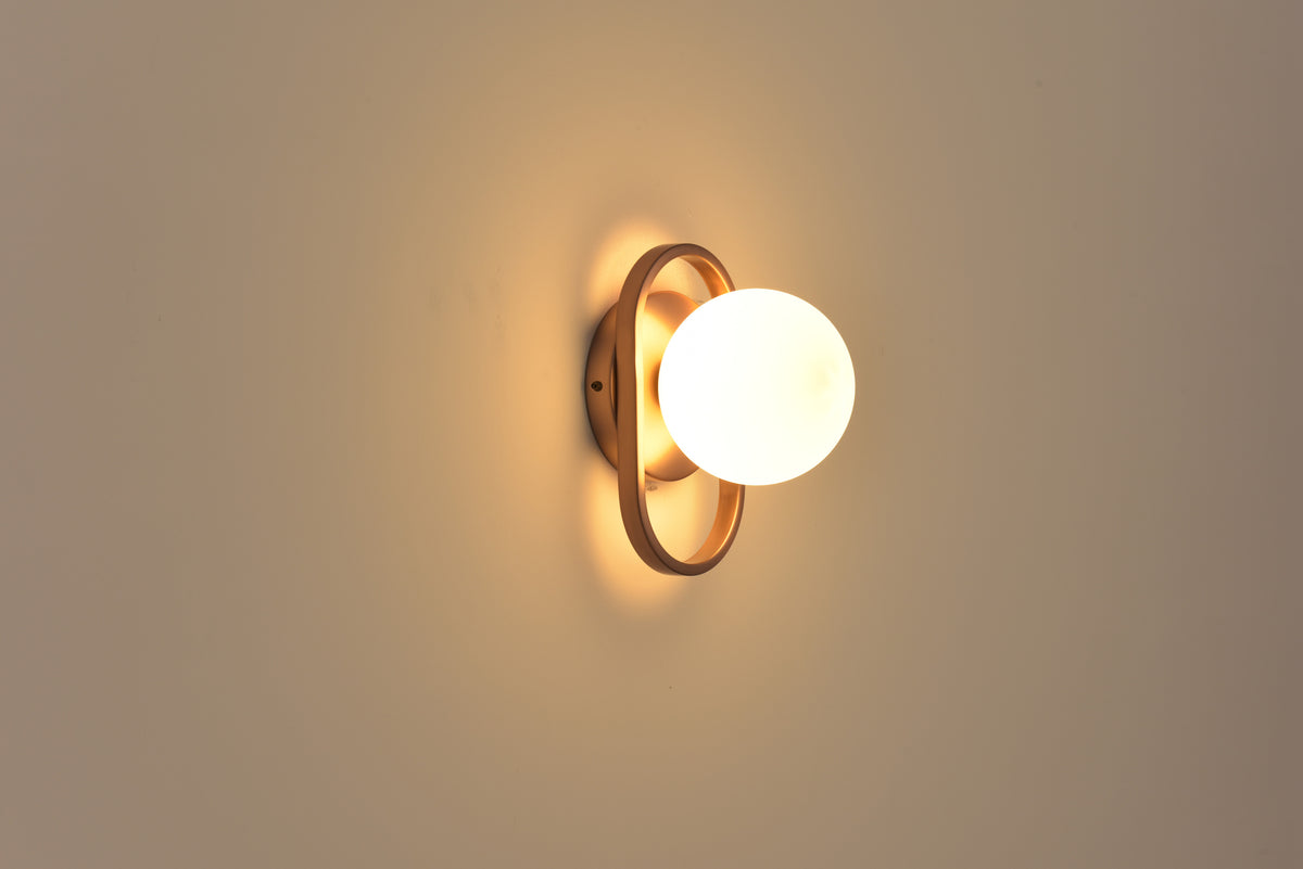 Wandlamp Jessica in brons brandend in een donkere ruimte met warme gloed