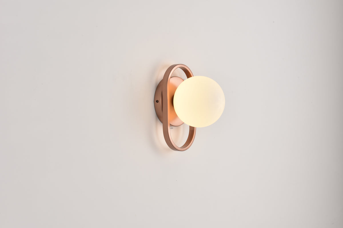 Wandlamp Jessica in brons brandend met zacht licht tegen een lichte wand