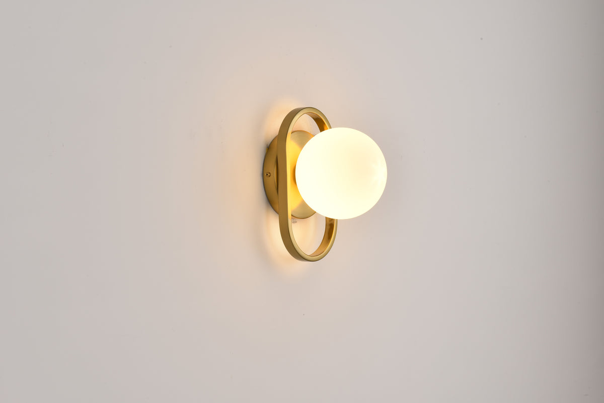 Wandlamp Jessica in goud met ovale beugel en witte bol tegen een witte wand