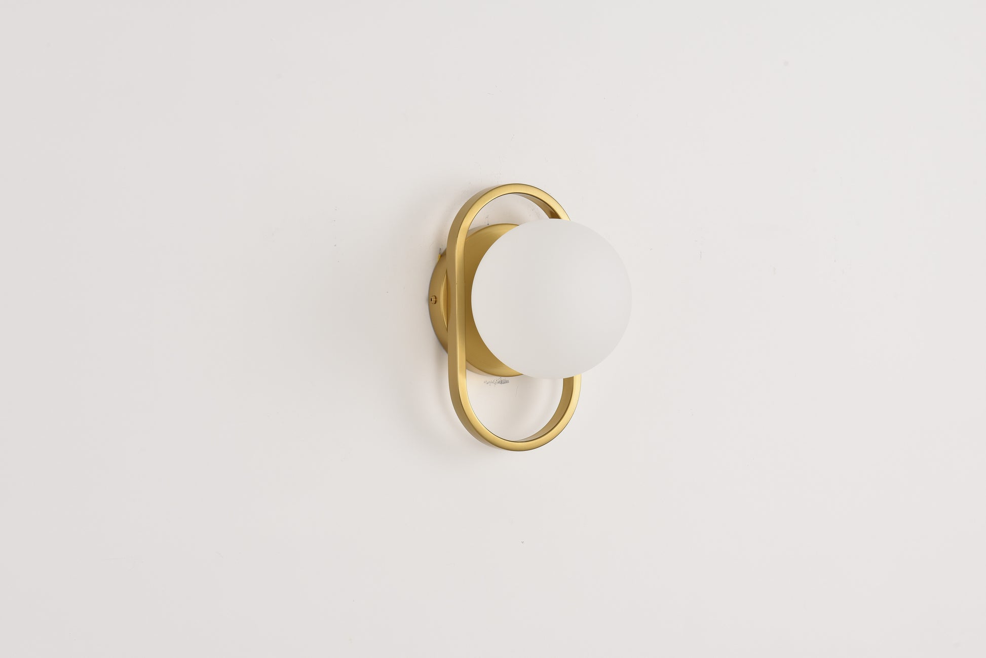 Wandlamp Jessica in goud brandend met warme gloed rond de beugel