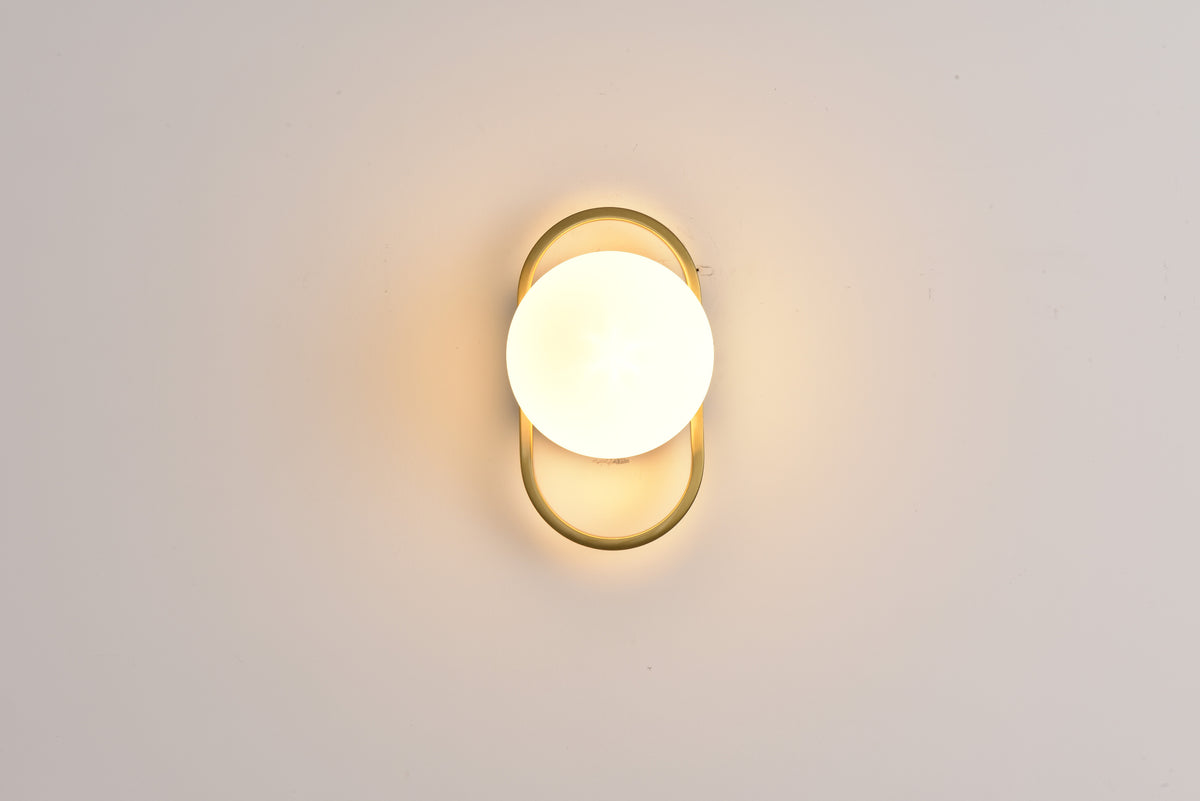 Wandlamp Jessica in goud brandend recht van voren met warm licht rondom