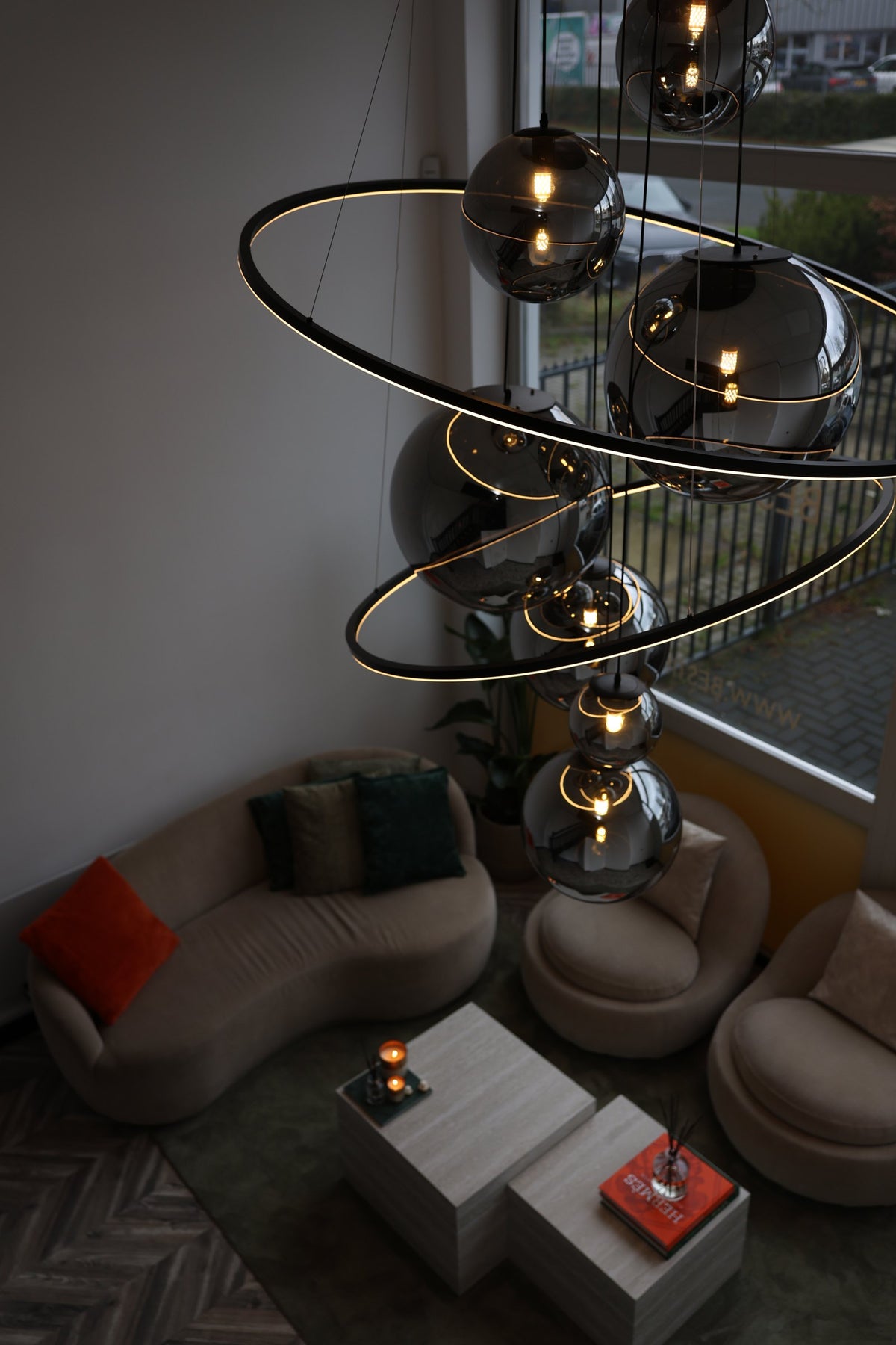 Rookglazen bollampen en verlichte ringen in de showroom bij avondlicht