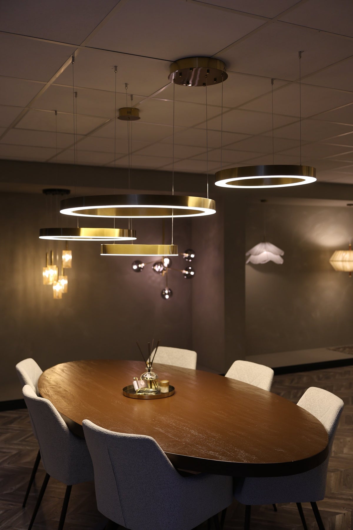 Eettafel in de showroom met messing ringlampen erboven