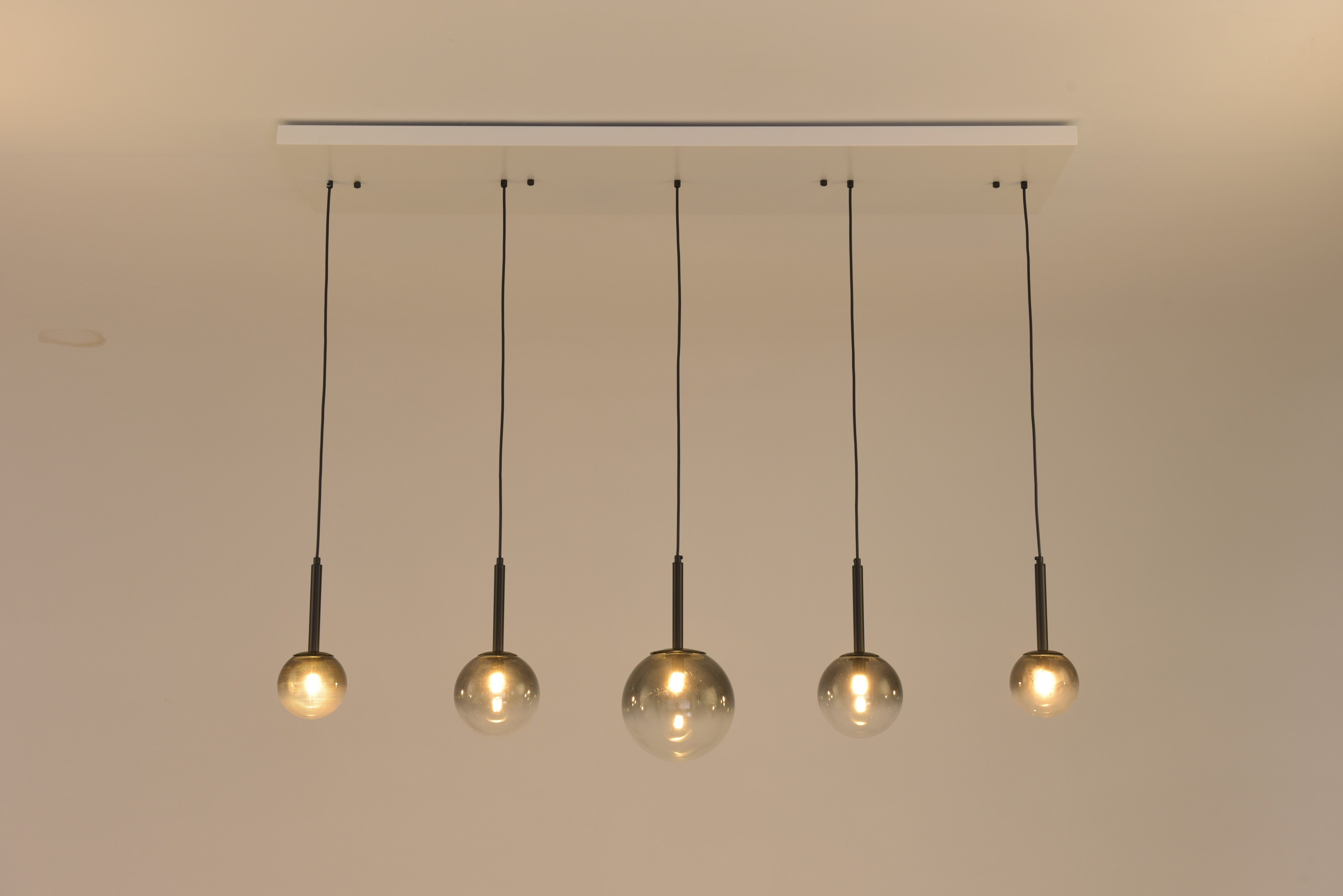 Hanglamp Stellar brandend met warm licht in de vijf glazen bollen