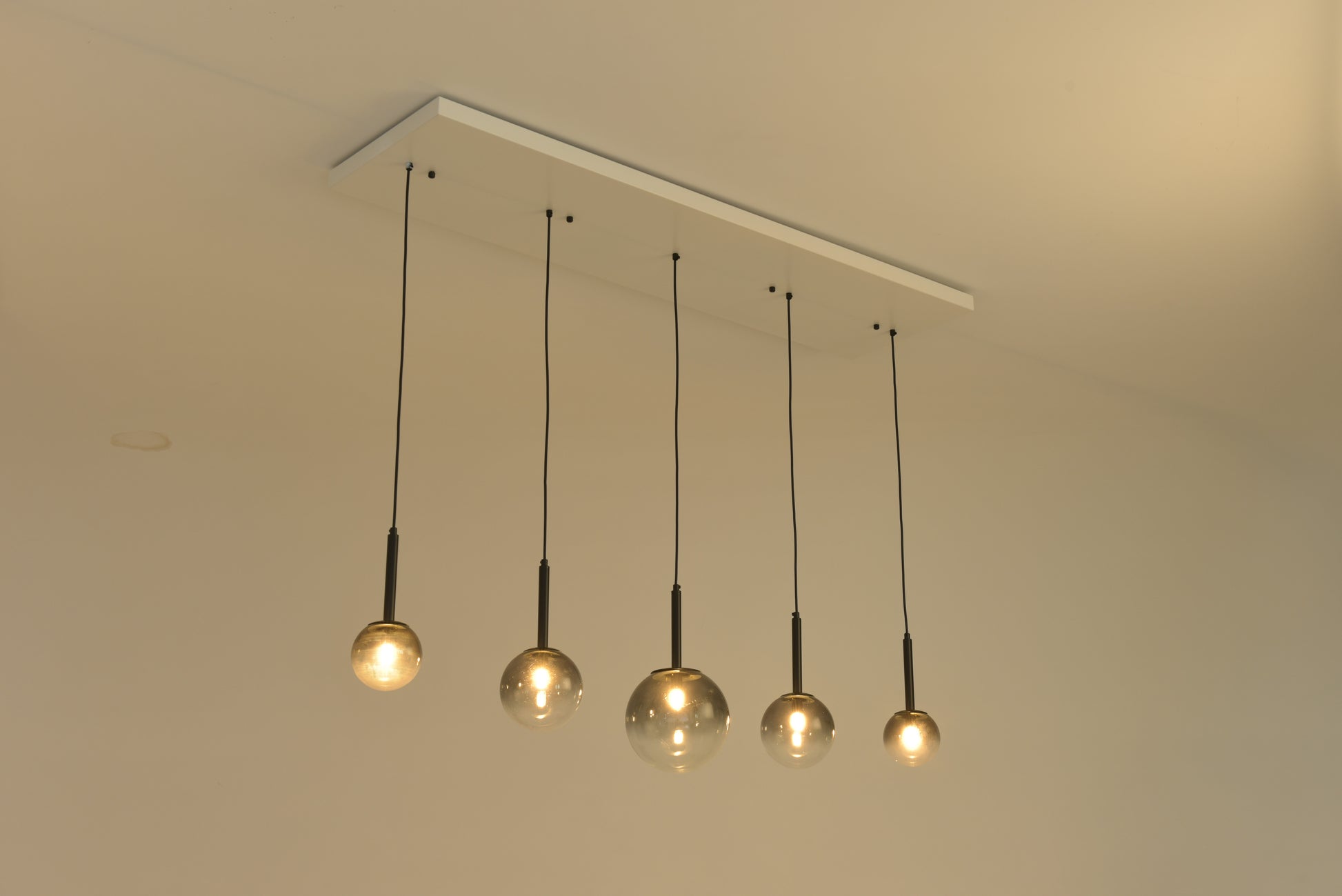 Hanglamp Stellar schuin gezien met warm brandende bollen boven een tafel