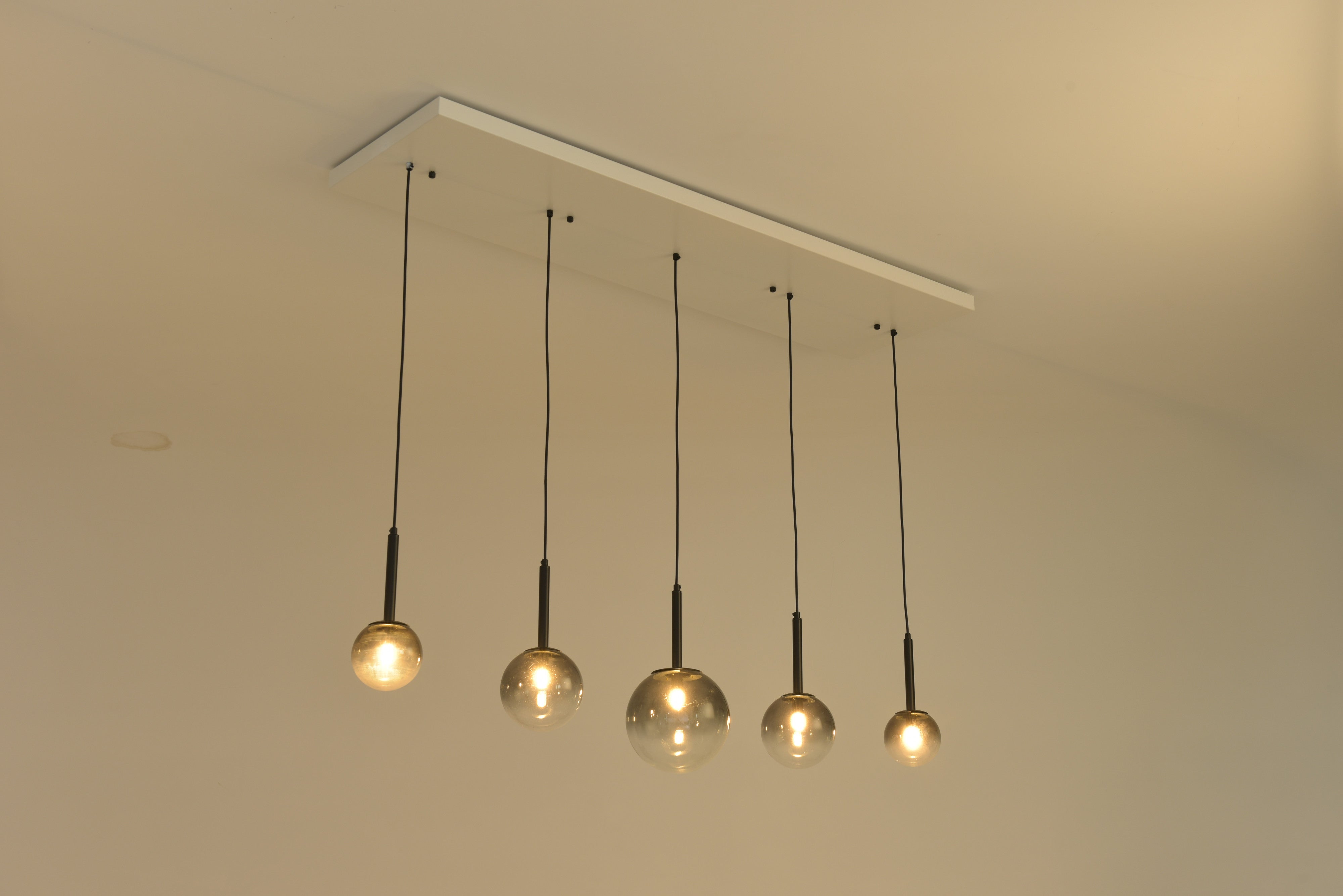 Hanglamp Stellar schuin gezien met warm brandende bollen boven een tafel