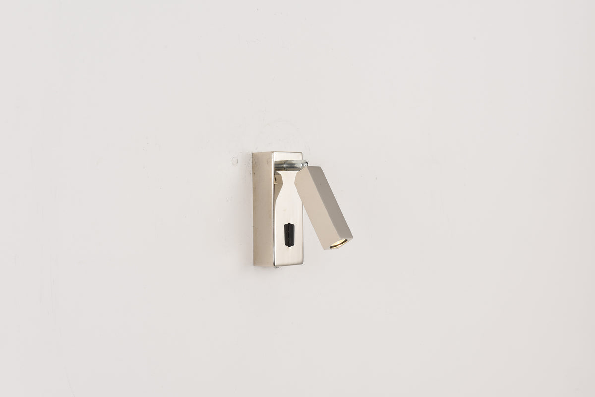 Wandlamp Vero in nikkel met uitgeklapte richtbare leespot tegen een witte wand