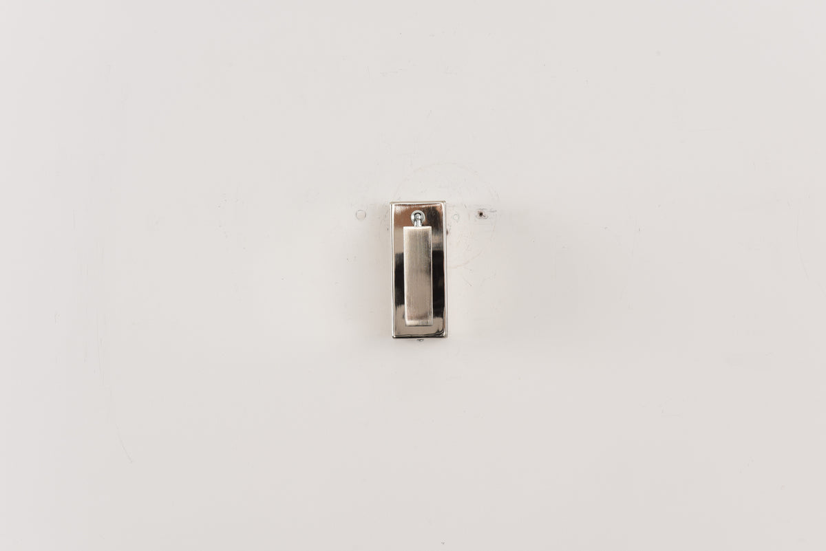 Wandlamp Vero in nikkel met de spot volledig ingeklapt tegen een witte wand